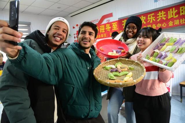在江苏省镇江市金湖社区，江苏大学的外国留学生与包好的饺子自拍“合影”。石玉成 摄